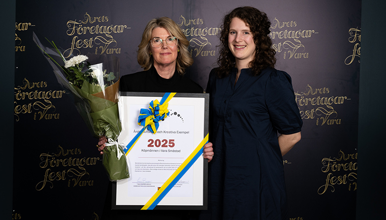 Två kvinnor med diplom och blommor i händerna.