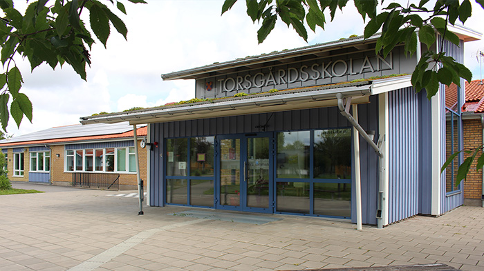 Entré till skolbyggnad, texten Torsgårdsskolan ovanför dörren.