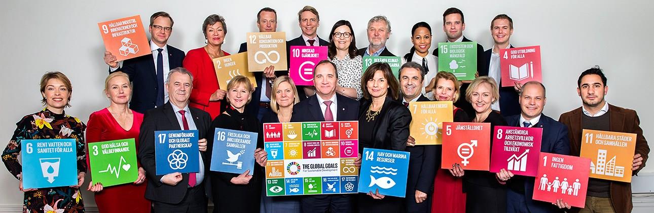 Gruppbild över personer som håller i färgglada kuber med globala målen.