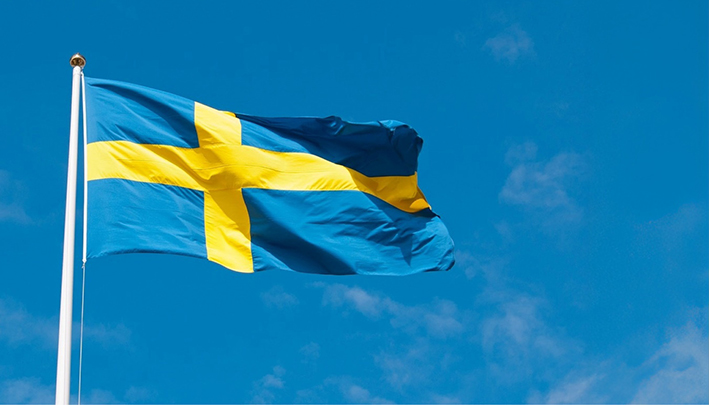 Blå och gul flagga som vajar mot en blå himmel