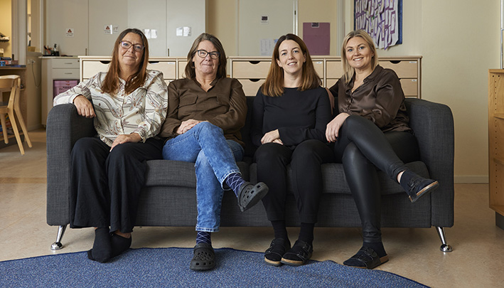 Fyra kvinnor sitter i en soffa i ett klassrum