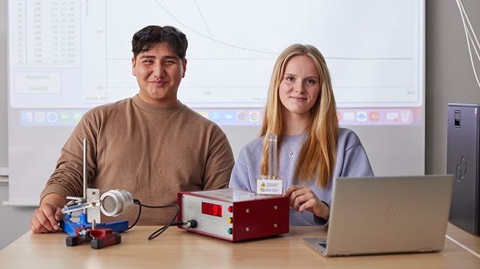 Två elever som sitter vid ett bord med tekniska instrument. 