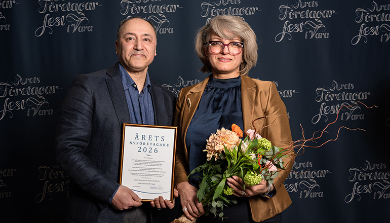 En man och en kvinna med diplom och blommor i händerna.