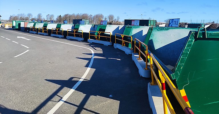 Gröna containrar för återvinning står på rad