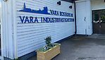 Entré till ett kontor, vit träfasad, med en skylt med texten Vara Bostäder och Vara Industribostäder.